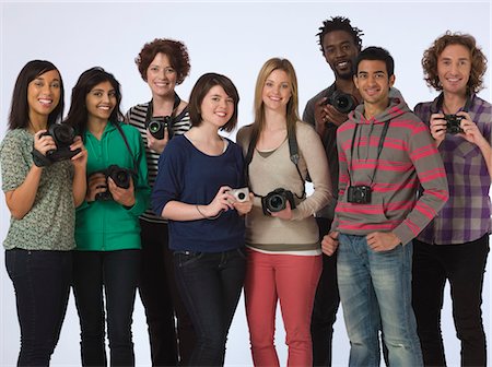 portrait de groupe - Portrait de groupe de jeunes gens holding caméras, studio shot Photographie de stock - Premium Libres de Droits, Code: 693-03316387