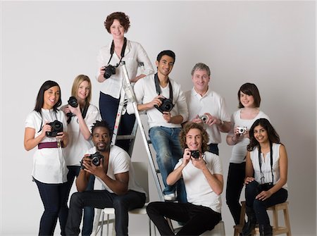 dslr-camera - Group portrait of young photographers sitting on ladder and chairs Stock Photo - Premium Royalty-Free, Code: 693-03316389