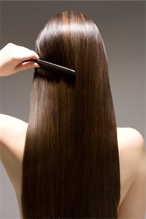 Woman combing long brown hair, rear view Stock Photo - Premium Royalty-Free, Code: 693-03316527