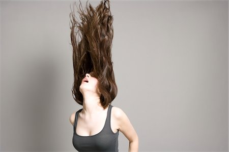 Woman tossing long brown hair Stock Photo - Premium Royalty-Free, Code: 693-03316538