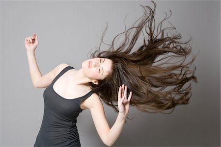 Woman with long brown hair, dancing Stock Photo - Premium Royalty-Free, Code: 693-03316539