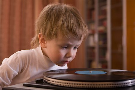 Boy listening to record player Fotografie stock - Premium Royalty-Free, Codice: 693-03316757