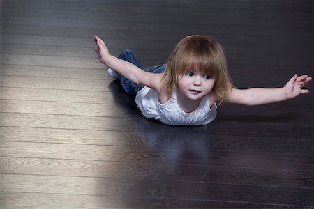 Little girl lying on floor and doing exercises Stock Photo - Premium Royalty-Free, Code: 693-03316825