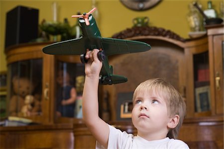 Garçon jouant avec modèle réduit d'avion chez Photographie de stock - Premium Libres de Droits, Code: 693-03317037