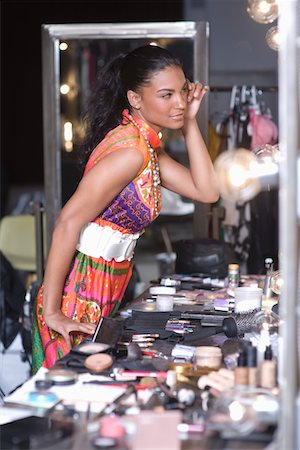 Woman applies makeup in dressing room mirror Stock Photo - Premium Royalty-Free, Code: 693-03317143