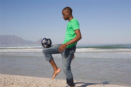 Young man playing soccer on beach Fotografie stock - Premium Royalty-Free, Codice: 693-03317184