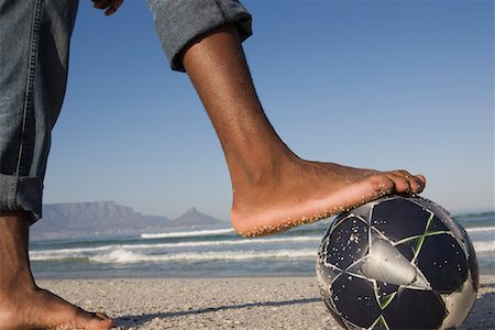 Foot on soccer ball, beach scene Stock Photo - Premium Royalty-Free, Code: 693-03317181