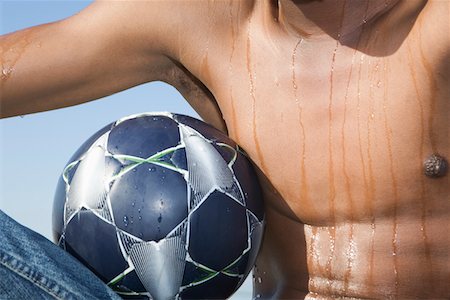 sweat not exercise not fitness - Mans torso with soccer ball Stock Photo - Premium Royalty-Free, Code: 693-03317183