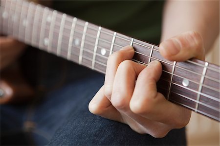 frente - Young man playes chord on guitar Stock Photo - Premium Royalty-Free, Code: 693-03317266