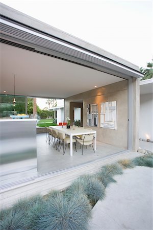 Glass wall of open plan dining / kitchen area in Palm Springs home Stock Photo - Premium Royalty-Free, Code: 693-03317356