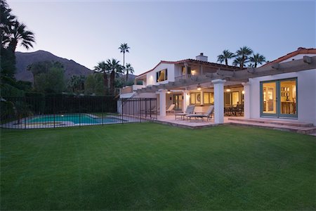 simsearch:693-03317404,k - Lawn and swimming pool with lit exterior of Palm Springs home exterior Foto de stock - Royalty Free Premium, Número: 693-03317387