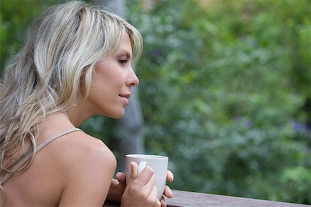 Blonde woman sits with cup on garden veranda Stock Photo - Premium Royalty-Free, Code: 693-03317534