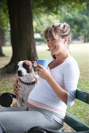 Pregnant woman on park bench with dog Foto de stock - Sin royalties Premium, Código: 693-03317780