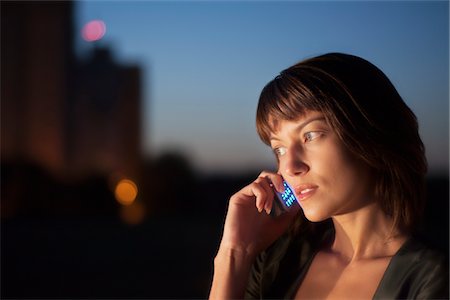 Woman talks on mobile phone at night Stock Photo - Premium Royalty-Free, Code: 693-03317900