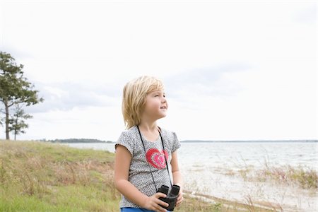 Girl stands with binoculars at lakeside Foto de stock - Sin royalties Premium, Código: 693-03317966