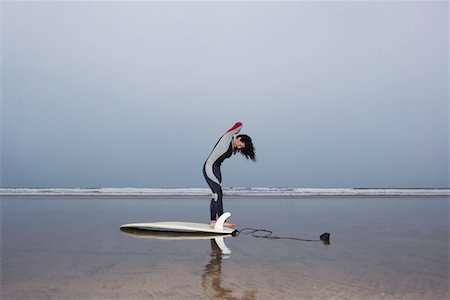 Female surfer standing in shallow water, side view Stock Photo - Premium Royalty-Free, Code: 693-03310147