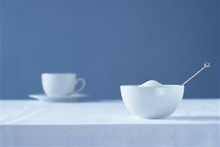 Bowl of sugar on table, tea cup in background Foto de stock - Sin royalties Premium, Código: 693-03310956