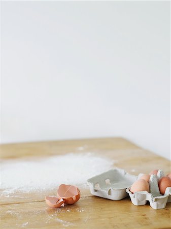 eggs on table - Eggs and flour scattered on table top Stock Photo - Premium Royalty-Free, Code: 693-03311002