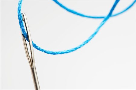 sewing needle close up - Blue thread going through needle eye, close-up Stock Photo - Premium Royalty-Free, Code: 693-03311157