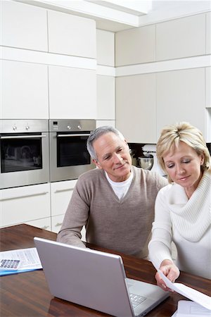 simsearch:693-03311596,k - Couple d'âge mûr travaillant sur ordinateur portable dans la cuisine Photographie de stock - Premium Libres de Droits, Code: 693-03311275