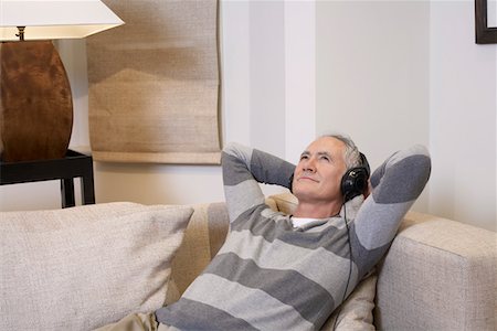 simsearch:693-03305464,k - Middle-aged man listentening to music on headphones in living room Stock Photo - Premium Royalty-Free, Code: 693-03311282