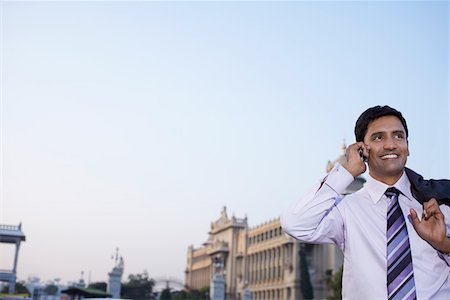 Business man using cell phone, smiling Stock Photo - Premium Royalty-Free, Code: 693-03311472