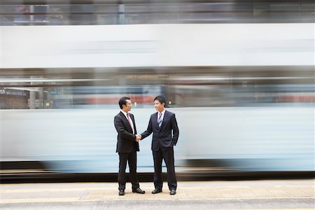 standing downtown - China, Hong Kong, two business man shaking hands, standing on street crossing, long exposure Stock Photo - Premium Royalty-Free, Code: 693-03311563