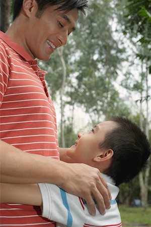 simsearch:693-06379441,k - Father and son (7-9) in park, embracing and looking in eyes Stock Photo - Premium Royalty-Free, Code: 693-03311625