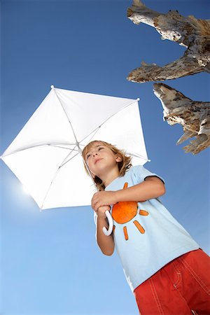 Boy (7-9) holding beach umbrella, view from below Stock Photo - Premium Royalty-Free, Code: 693-03311859
