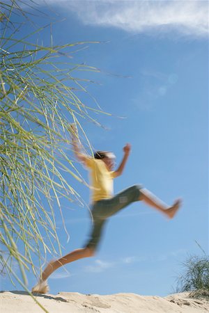 Boy (10-12) jumping on sand dune Stock Photo - Premium Royalty-Free, Code: 693-03311852
