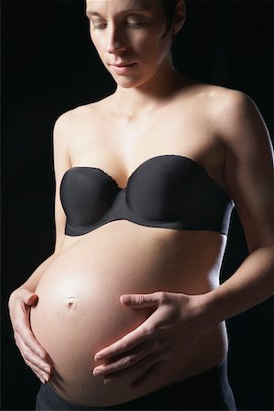 simsearch:693-03315753,k - Pregnant woman touching abdomen, studio shot Stock Photo - Premium Royalty-Free, Code: 693-03312026