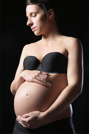 simsearch:693-03315753,k - Pregnant woman touching abdomen, studio shot Stock Photo - Premium Royalty-Free, Code: 693-03312027