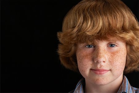 freckle shoulders - Boy (10-12) on black background, portrait, close-up Stock Photo - Premium Royalty-Free, Code: 693-03312072