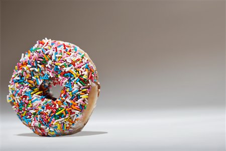 Rainbow sprinkles on doughnut Foto de stock - Sin royalties Premium, Código: 693-03312120