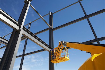 Welder working from cherry picker on warehouse construction Stock Photo - Premium Royalty-Free, Code: 693-03312196