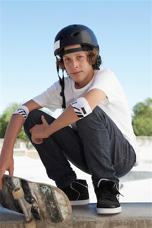 pista de skate - Teenage boy (16-17) with skateboard at skateboard park, portrait Foto de stock - Royalty Free Premium, Número: 693-03312300