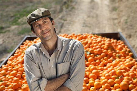 Portrait of farmer leaning on trailer with oranges Stock Photo - Premium Royalty-Free, Code: 693-03312671