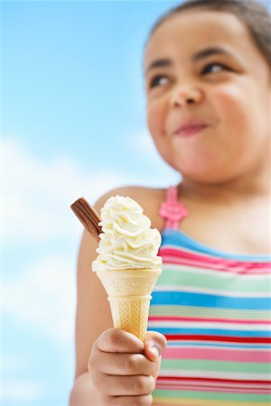 Girl (7-9 years) holding icecream, focus on icecream Stock Photo - Premium Royalty-Free, Code: 693-03363704