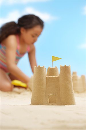 simsearch:693-03307029,k - Girl (7-9 years) building sand castles on beach, focus on sand castle in foreground Foto de stock - Sin royalties Premium, Código: 693-03363701