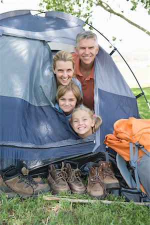 Family of four smiling from a tent Stock Photo - Premium Royalty-Free, Code: 693-03440759