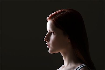 profile portrait black background - Young woman side view portrait Stock Photo - Premium Royalty-Free, Code: 693-03440804