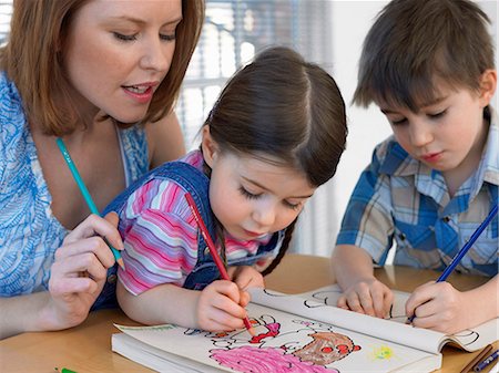 Mother and children (3-6) colouring in book, at home Stock Photo - Premium Royalty-Free, Code: 693-03450604