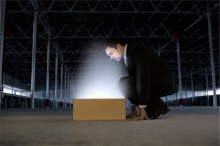 Man peers into yellow box shining bright light Stock Photo - Premium Royalty-Free, Code: 693-03474173