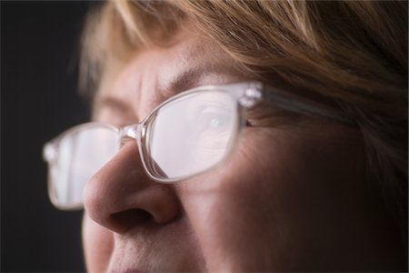 elderly face - Mature woman with light reflecting on reading glasses Stock Photo - Premium Royalty-Free, Code: 693-03474351