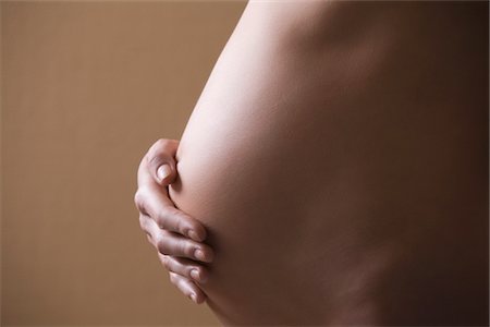 peau (anatomie) - Femme enceinte se tient avec la main sur le ventre Photographie de stock - Premium Libres de Droits, Code: 693-03474361