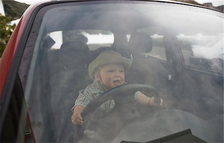 Toddler in the driving seat Foto de stock - Sin royalties Premium, Código: 693-03474405