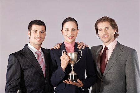 Businesswoman holding trophy with male colleagues, portrait Stock Photo - Premium Royalty-Free, Code: 693-03556994