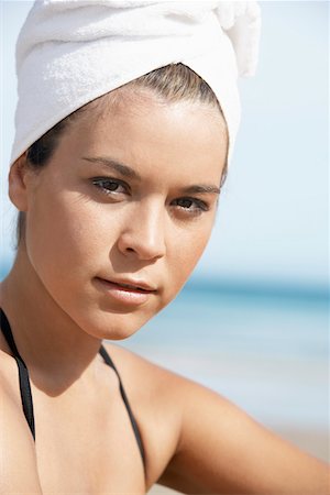 Young woman with hair wrapped in towel on beach, close-up Stock Photo - Premium Royalty-Free, Code: 693-03557053
