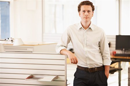 Mid-adult male office worker standing by cubicle, portrait Stock Photo - Premium Royalty-Free, Code: 693-03557178