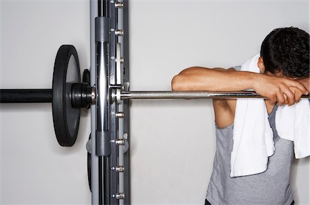 exhausted gym - Sweaty man resting on barbell after workout Stock Photo - Premium Royalty-Free, Code: 693-03557201